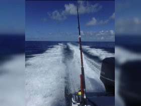 A scenic view from a fishing boat, showcasing the ocean waves and a fishing rod, perfect for capturing the thrill of a day on the water.