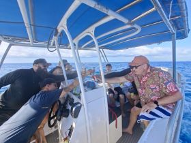A lively group enjoys drinks and camaraderie aboard a boat, capturing the essence of fun on the water with friends and family.