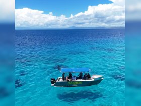A vibrant boat navigates through stunning turquoise waters, showcasing a perfect day for adventure on the ocean.