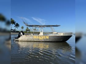 A sleek view of the Magnum Express boat, showcasing its design and structure against a clear blue sky, perfect for fishing or leisure trips.
