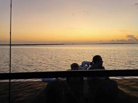 A serene sunset view from a boat with a family enjoying the moment — perfect for fishing trips and creating lasting memories on the water.