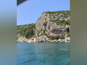A stunning view of rocky cliffs and clear turquoise waters, showcasing the natural beauty of the coastline — perfect for scenic boat tours.