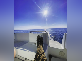 A person relaxes on the deck of a boat, enjoying the sunshine and the serene ocean view — a perfect moment for unwinding on the water.