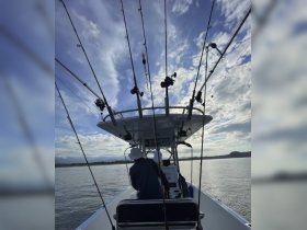 A view from inside a fishing boat showcasing the helm and fishing gear, with crew members preparing for a day on the water.