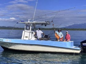 A group of anglers proudly display their catch aboard a fishing boat, enjoying a beautiful day on the water. Perfect for fishing enthusiasts and adventure seekers.
