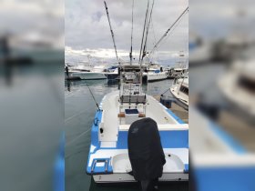 A detailed view of the interior of a fishing boat, showcasing the helm and fishing gear, perfect for anglers looking to set out on their next adventure.