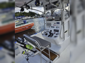 An interior view of a fishing boat's helm, showcasing the console and fishing gear, perfect for anglers looking to set out on their next adventure.