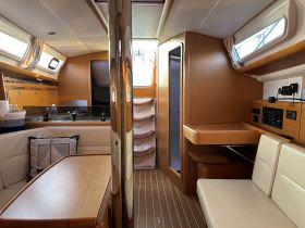 Interior view of a well-appointed boat cabin featuring comfortable seating and a functional helm area, perfect for relaxing or navigating on the water.