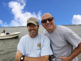 Two friends share a joyful moment on the water, showcasing the fun and camaraderie of a day out boating. Perfect for capturing memories with friends on the ocean.