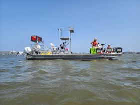 A lively scene on the water featuring a group enjoying their time aboard a boat, showcasing the fun and excitement of on-water activities.