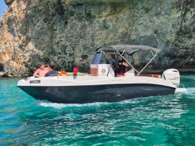 A group enjoys a sunny day on the water aboard a boat, with one person giving a thumbs up — perfect for family outings and adventures.