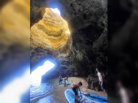 A group enjoys paddleboarding in a stunning cave setting, showcasing the beauty of outdoor adventures and water activities.