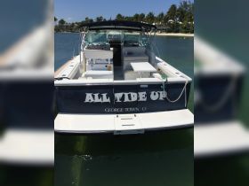 A clear view of the 'All Tide Up' boat docked in tranquil waters, showcasing its sleek design and inviting interior, perfect for day trips in George Town.