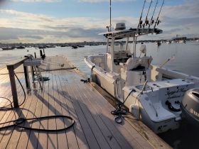 A sleek speedboat named 'Keepin' it Reel' is docked at a marina, surrounded by calm waters and a picturesque sky, perfect for fishing or leisure outings.