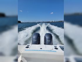 A dynamic view of a speedboat in motion, showcasing the powerful twin engines and the wake trailing behind, perfect for thrill-seekers and water enthusiasts.