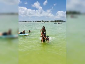A lively group enjoys a fun day in the water, showcasing a playful moment while snorkeling and swimming — perfect for family adventures or group outings.