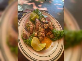 A delicious plate of grilled seafood garnished with lime and lettuce, perfect for enjoying onboard or at a seaside restaurant.