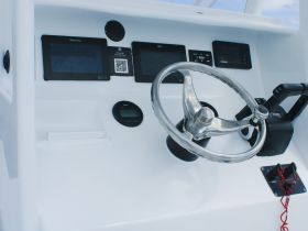 A sleek view of the helm and console area inside a boat, showcasing modern navigation equipment and controls, ideal for boating enthusiasts.