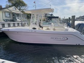 A sleek Robalo boat docked at the marina, showcasing its modern design and ready for a day on the water.