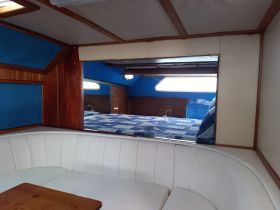 Interior view of a cozy boat cabin featuring comfortable seating and a sleeping area, perfect for relaxing during a day on the water.