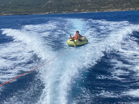 A child enjoys tubing in the open water, creating a thrilling experience on a sunny day — perfect for family fun and water adventures.