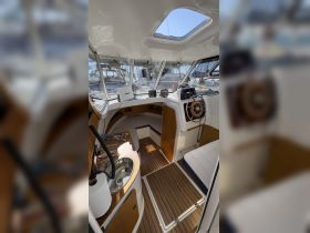 Interior view of a well-equipped boat helm featuring seating and navigation controls, perfect for comfortable cruising and sailing adventures.