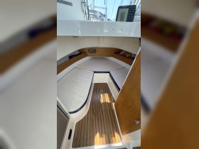 Interior view of a boat cabin featuring comfortable seating and a clean wooden floor, ideal for relaxing while on the water.