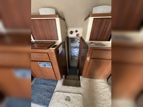 Interior view of a boat cabin showcasing the helm and cozy seating area, perfect for relaxing during your nautical adventures.