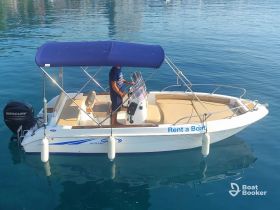A speedboat with a canopy is docked in calm waters, showcasing its sleek design and inviting atmosphere for a day on the water.