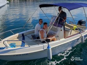 A group of friends enjoys a day on the water aboard a small boat, capturing the essence of fun and adventure in a beautiful setting.