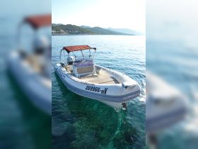 A sleek speedboat anchored in clear waters, showcasing its design and structure, perfect for a day of adventure on the sea.