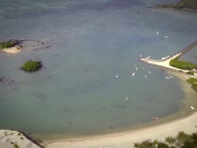 A stunning aerial view of a serene coastline featuring small boats and lush islands, perfect for showcasing the beauty of tropical destinations.