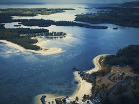 A stunning aerial view of a serene coastline with lush islands and sandy beaches, perfect for showcasing the beauty of tropical destinations.