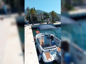 A sleek speedboat named 'Peppa' docked at a picturesque marina, surrounded by palm trees and scenic hills, perfect for a day on the water.