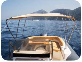A well-appointed helm area of a boat, featuring comfortable seating and a clear view of the serene waters and mountains in the background, perfect for a day out on the water.