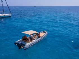 A lively group enjoys a day on the water aboard a boat, surrounded by stunning blue ocean — perfect for summer adventures and family outings.