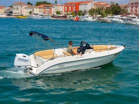 A sleek speedboat navigates through clear waters, showcasing its elegant design and powerful engine — perfect for a day of adventure on the water.