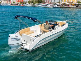 A man navigates a sleek speedboat through vibrant waters, showcasing the perfect blend of adventure and relaxation on the open sea.