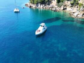 An aerial view of a boat anchored in stunning turquoise waters, showcasing a picturesque coastal scene perfect for summer adventures.