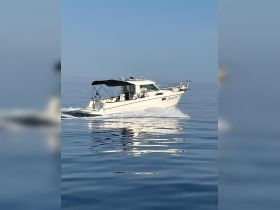 A sleek speedboat glides smoothly across calm waters, showcasing its elegant design and perfect for a day of fishing or leisure on the sea.