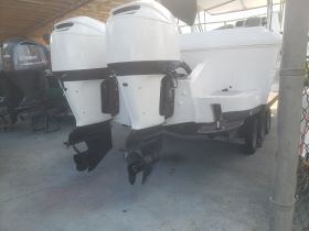 A close-up view of a boat's outboard motors, showcasing the vessel's structure while docked. Ideal for boat enthusiasts and potential buyers.