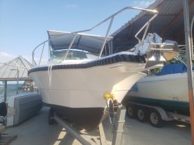 A clear view of a boat's exterior, showcasing its sleek design while docked. Ideal for boat enthusiasts and potential buyers.