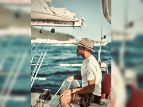 A man actively sailing on a boat, enjoying the ocean breeze and the thrill of the sea — a perfect moment for sailing enthusiasts.
