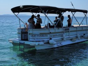 A lively group enjoys their time aboard a pontoon boat, creating unforgettable memories in the crystal-clear waters.