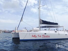 A beautiful catamaran named 'Jolly Cat Charters' docked in calm waters, showcasing its sleek design against a scenic backdrop.