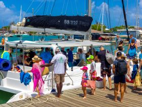 A lively group boards a catamaran for an exciting excursion, with families and children ready for a day on the water.