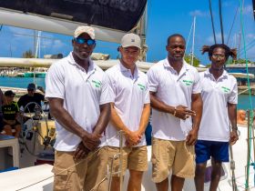 The crew of Hobby Lobby Tours poses on their sailing vessel, ready to welcome guests for an unforgettable maritime adventure.
