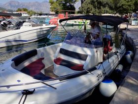A well-appointed boat interior featuring comfortable seating and a helm, perfect for leisurely outings on the water.