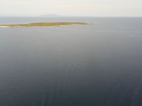 A distant view of an island surrounded by water, with unclear visibility and no identifiable features.
