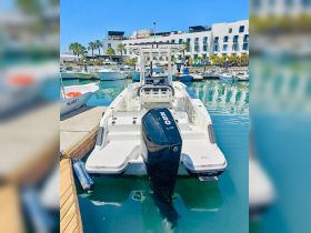 A sleek speedboat docked at a marina, showcasing its powerful engine and modern design — perfect for thrilling water adventures.
